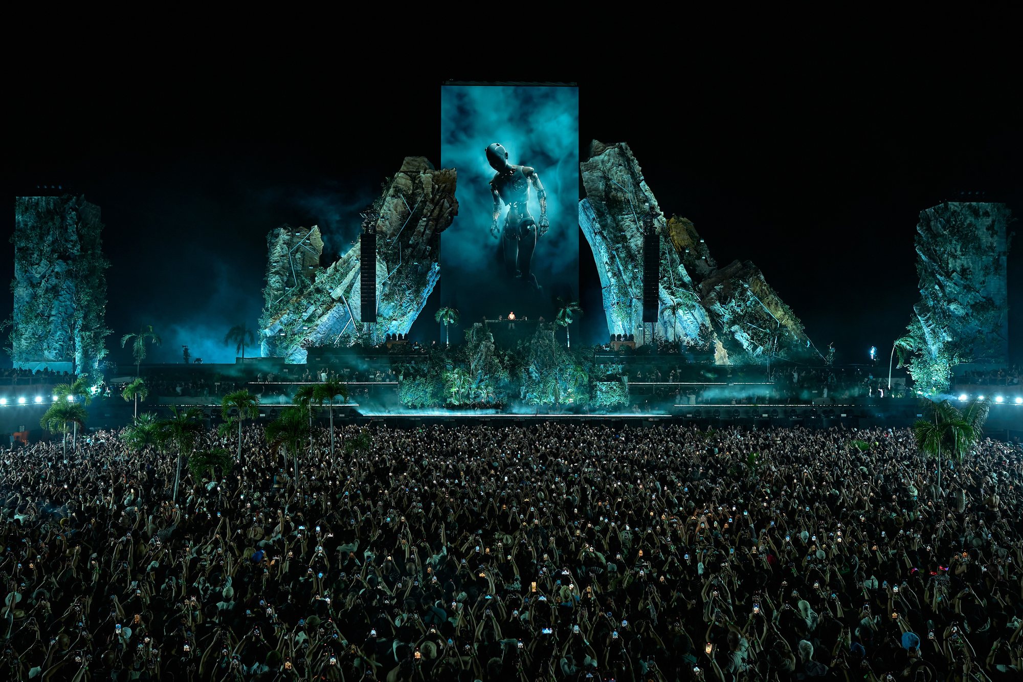 Zamna Tulum stage framed by rock structures, with the crowd at night